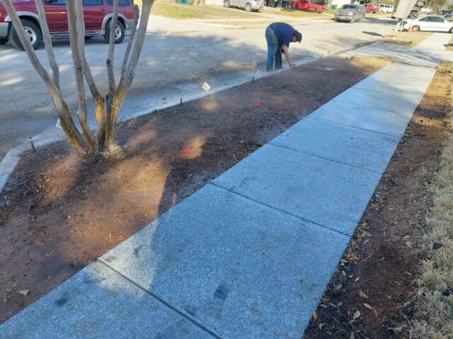 new sprinkler line with heads, tech is adjusting heads for coverage